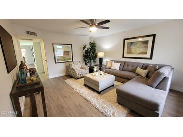 Inviting living room featuring a comfortable gray sectional, patterned armchair, and a plush area rug at 7950 E Keats Ave # 150, Mesa, AZ 85209