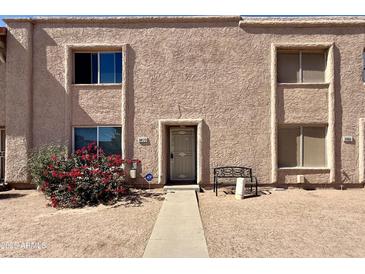 Inviting townhome featuring a stucco facade, complemented by mature landscaping and a cozy front entry at 8410 N 32Nd Ave, Phoenix, AZ 85051