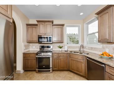 Traditional kitchen with granite counters, stainless appliances, and tile backsplash at 964 S Henry Ln, Gilbert, AZ 85296