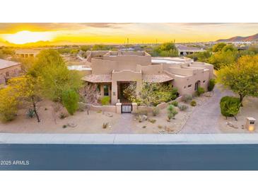 Stunning home with desert landscaping, iron gate, and paver walkway at sunset at 10396 N 133Rd St, Scottsdale, AZ 85259