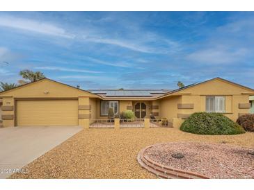 Inviting single-story home with low-maintenance desert landscaping, solar panels, and covered entryway at 10726 W Pineaire Dr, Sun City, AZ 85351