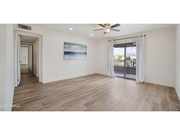 Bright living room featuring hardwood floors, a ceiling fan, and a sliding door leading to a balcony at 16657 E Gunsight Dr # 233, Fountain Hills, AZ 85268