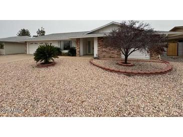 Charming single-story home featuring a low-maintenance rock yard and mature landscaping at 18034 N 129Th Ave, Sun City West, AZ 85375