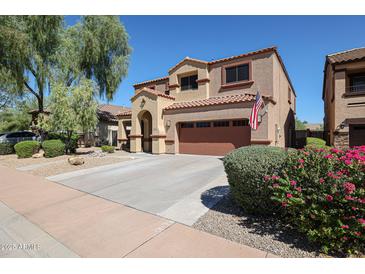 Two-story stucco home featuring a two-car garage, tile roof, arched entry, and landscaped front yard at 22927 N 41St St, Phoenix, AZ 85050