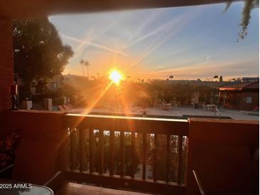 Balcony view of a community pool with lounge chairs under a vibrant sunset sky in a relaxing atmosphere at 3031 N Civic Center Plz # 261, Scottsdale, AZ 85251