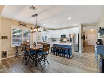 Spacious open-concept kitchen with stainless steel appliances, island seating, and a connected dining area at 3716 E Andre Ave, Gilbert, AZ 85298