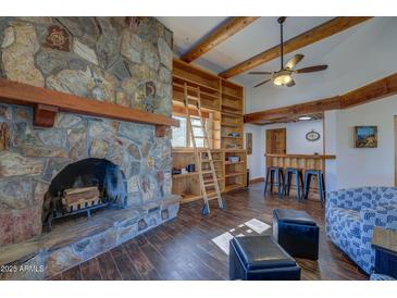 Inviting living room showcasing a stone fireplace, built-in shelves, and warm wooden beam accents at 40445 N 32Nd St, Cave Creek, AZ 85331