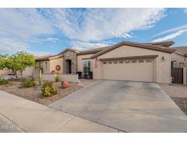 Charming home showcasing desert landscaping, large driveway, and attached two-car garage at 4709 E Blue Spruce Ln, Gilbert, AZ 85298