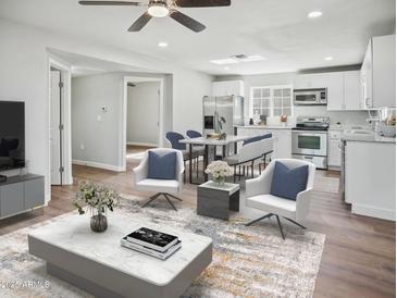 Bright living space with wood floors, ceiling fan, dining area, and open access to the kitchen at 533 N Sirrine --, Mesa, AZ 85201