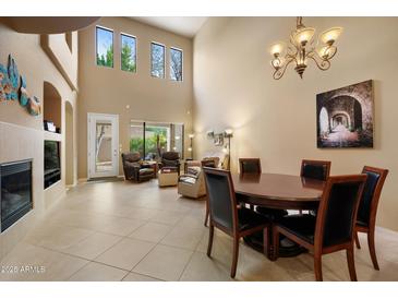 Spacious living room with fireplace, high ceilings, and a dining area with seating for four at 7445 E Eagle Crest Dr # 1094, Mesa, AZ 85207