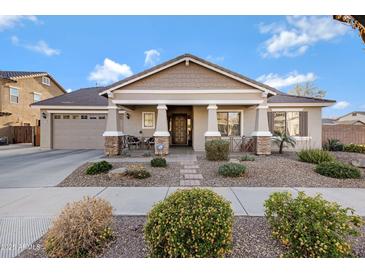 Charming single-story home featuring a well-manicured front yard, covered porch, and attached two-car garage at 19025 E Raven Dr, Queen Creek, AZ 85142