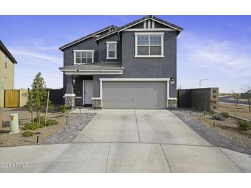 Charming two-story home featuring a gray exterior, well-maintained landscaping, and a spacious driveway at 47558 W Mellen Ln, Maricopa, AZ 85139