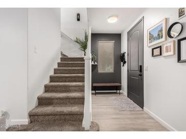 Inviting entryway with a modern gray door and a staircase leading to the upper level at 7840 W Bonitos Dr, Phoenix, AZ 85035