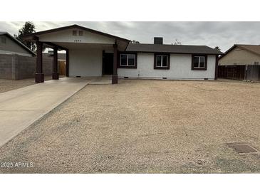 Charming single-story home with covered parking and low maintenance gravel front yard at 7955 W Mackenzie Dr, Phoenix, AZ 85033