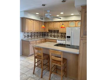 Well-equipped kitchen with a breakfast bar, tile backsplash, and modern appliances at 8538 E Vista Dr, Scottsdale, AZ 85250