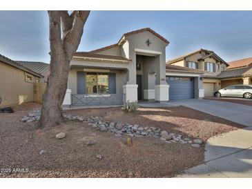 Charming single-story home featuring a desert-landscaped front yard and a two-car garage at 10353 W Atlantis Way, Tolleson, AZ 85353