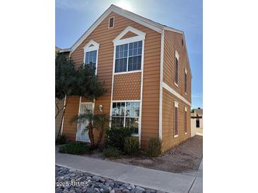 Two story home featuring brown wood siding, white trim, and manicured landscaping at 1970 N Hartford St # 11, Chandler, AZ 85225