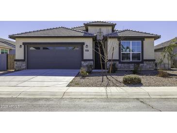 Charming single-story home with a gray garage door, tiled roof, and low maintenance front yard at 38197 W San Clemente St, Maricopa, AZ 85138
