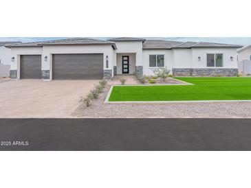Charming single Gathering home with a two car garage, easy to maintain lawn, and neutral tones at 7295 S 221St Ave, Buckeye, AZ 85326