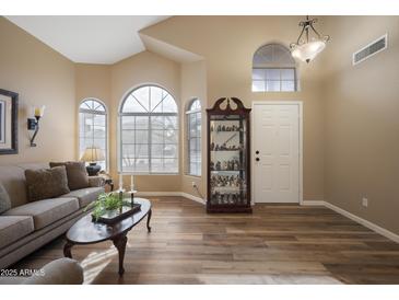 Inviting living room featuring ample natural light, wood floors, and neutral tones at 12926 W Pershing St, El Mirage, AZ 85335