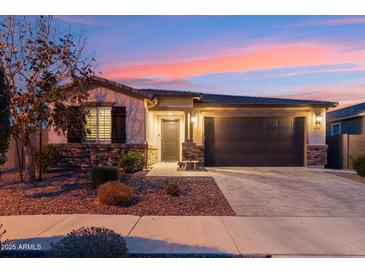 Charming single-story home featuring stone accents, a covered entryway, and a well-manicured front yard with desert landscaping at 16278 W Jenan Dr, Surprise, AZ 85379