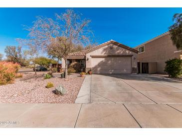 Charming single-story home featuring a two-car garage and desert landscaping with cacti and drought-tolerant plants at 17634 W Hearn Rd, Surprise, AZ 85388