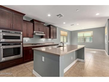 Modern kitchen with stainless steel appliances, granite counters, and a central island at 3025 W Night Owl Ln, Phoenix, AZ 85085