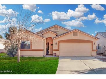 Charming single-story home features a two-car garage, a well-maintained lawn, and desert landscaping at 815 E Centre Ave, Buckeye, AZ 85326