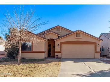 Charming single-story home featuring a two-car garage and a well-maintained front yard in a suburban neighborhood at 815 E Centre Ave, Buckeye, AZ 85326