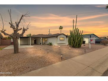 Charming single-story home showcasing desert landscaping, brick driveway, carport, and welcoming entrance at 8252 E Heatherbrae Ave, Scottsdale, AZ 85251