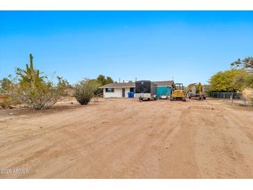 A vast dirt backyard featuring construction equipment and trailers, under a clear blue sky at 11512 E 6Th Ave, Apache Junction, AZ 85120