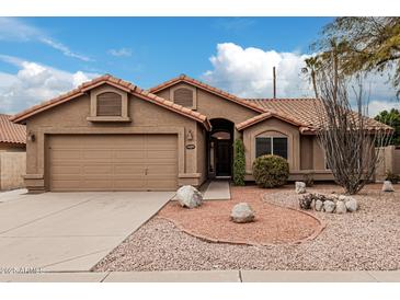 Charming single-story home with desert landscaping, a two car garage, and a terracotta tiled roof at 14404 N 56Th Pl, Scottsdale, AZ 85254