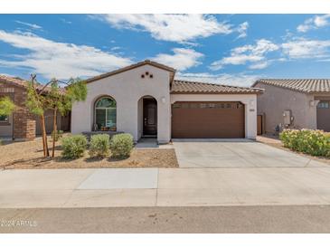 Charming single-story home with a well-manicured front yard and a two-car garage at 17055 W El Caminito Dr, Waddell, AZ 85355