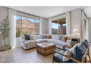 Comfortable living room with an oversized sectional, accent chairs, and views of the backyard and mountains at 1743 W Flintlock Dr, San Tan Valley, AZ 85144