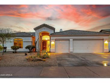 Charming home featuring a three-car garage, desert landscaping, and stunning sunset views at 22222 N 54Th Way, Phoenix, AZ 85054