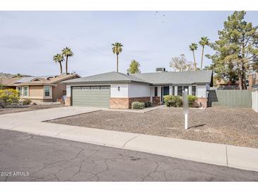 Charming single-story home featuring desert landscaping and a two-car attached garage at 4814 E Pearce Rd, Phoenix, AZ 85044