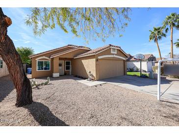 Charming single-story home with desert landscaping, a two-car garage, and a basketball hoop in the driveway at 853 E Ross Ave, Phoenix, AZ 85024