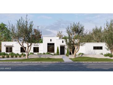 Contemporary home exterior featuring a flat roof, white stucco, dark framed windows and desert landscaping at 9611 E Clinton St, Scottsdale, AZ 85260