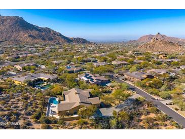 A beautiful aerial view of a home nestled amongst desert landscaping with mountains in the distance at 11415 E Four Peaks Rd, Scottsdale, AZ 85262