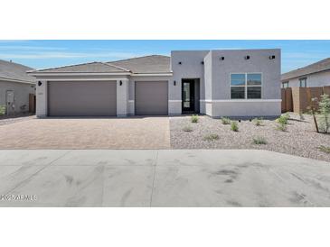 Beautiful single-story home featuring a well manicured gravel yard and a brick driveway leading to a two car garage at 18447 W Mohave St, Goodyear, AZ 85338