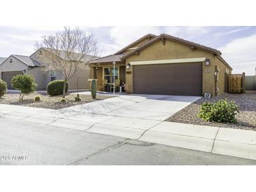Inviting single-story home featuring a well-maintained yard with desert landscaping and a spacious two-car garage at 1973 N Lewis Pl, Casa Grande, AZ 85122