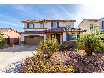 Two-story home with a two-car garage and a beautiful desert-landscaped front yard at 4727 S Watauga Dr, Gilbert, AZ 85297