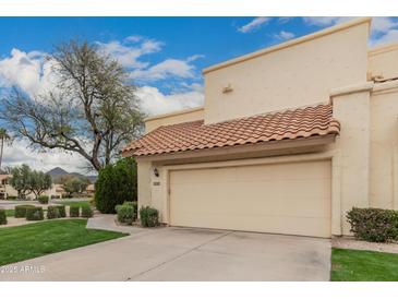 Charming home featuring a two-car garage, desert landscaping, and a tile roof at 13375 N 96Th Pl, Scottsdale, AZ 85260