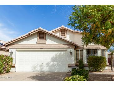 Charming home featuring a two-car garage, tile roof, and manicured landscaping at 20615 N 105Th Ave, Peoria, AZ 85382