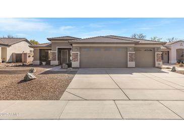 Charming single-story home featuring a three-car garage and desert-style landscaping at 2561 E Toledo Ct, Gilbert, AZ 85295