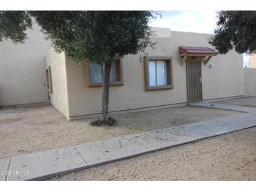 Tan single-story home with secure front door and mature trees at 4409 E Wood St, Phoenix, AZ 85040