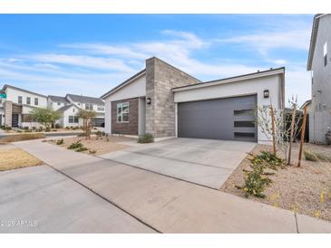 Attractive home featuring a modern design, stone accents, and a well-kept front yard at 5611 S Feliz --, Mesa, AZ 85212