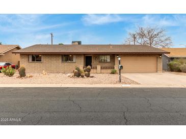 Charming single-story brick home with a two car garage and desert landscaping at 6917 E Flossmoor Ave, Mesa, AZ 85208