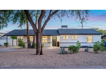 Charming single-story home featuring a well-maintained front yard with desert landscaping and mature trees at 1011 E Cavalier Dr, Phoenix, AZ 85014