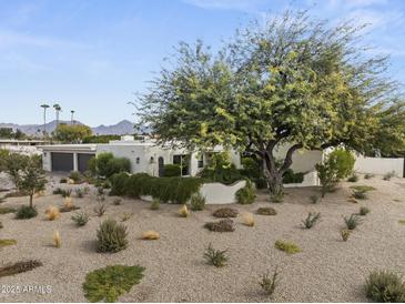 Charming home exterior with a beautiful tree and desert landscaping, offering curb appeal at 11601 N 85Th St, Scottsdale, AZ 85260